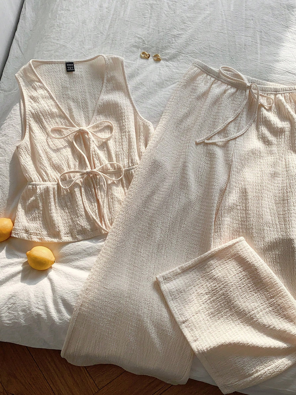 Conjunto de playa albaricoque con top anudado y pantalón largo sobre fondo claro.