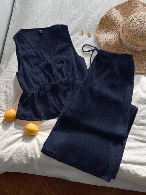 Conjunto casual de dos piezas azul marino sobre una superficie blanca.