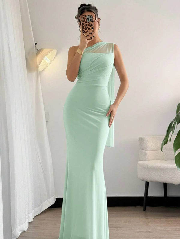 Mujer sosteniendo un bolso blanco mientras viste un vestido de fiesta largo color verde menta.