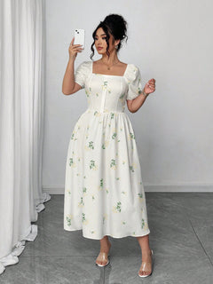 Mujer modelando el Vestido Blanco Estampado de frente mientras sostiene su teléfono.