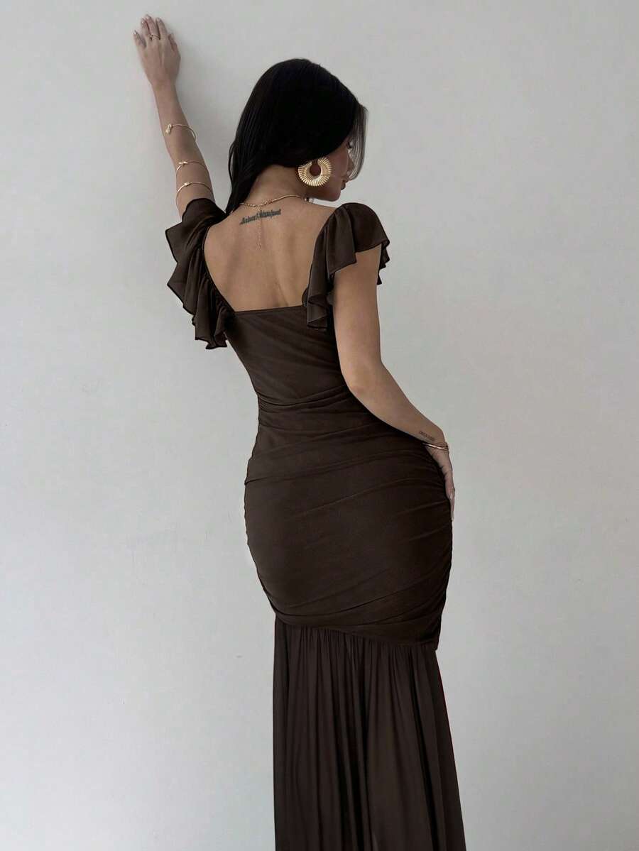 Mujer posando con un vestido largo marrón elegante de manga corta