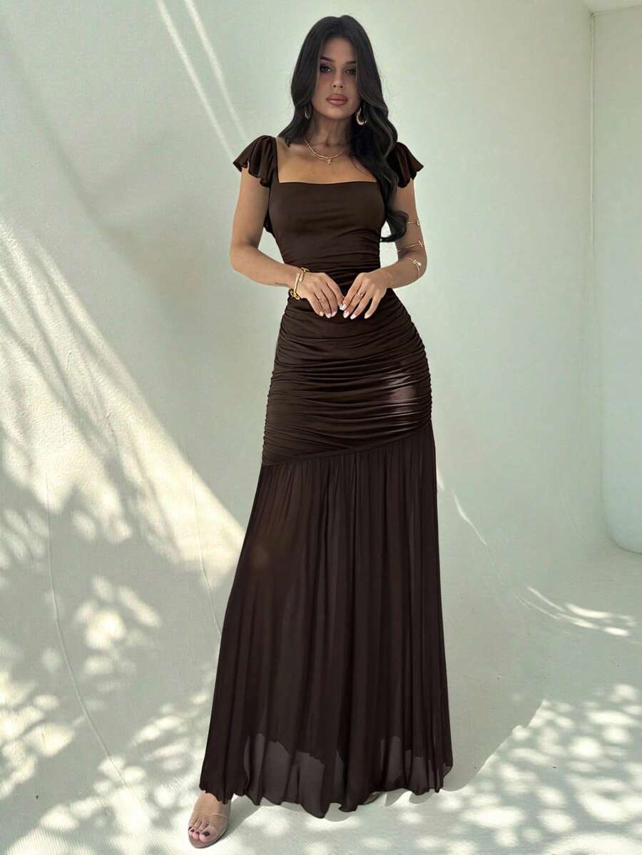 Mujer posando con un vestido largo marrón elegante de manga corta