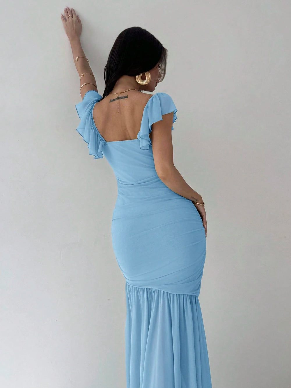 Vestido azul elegante con manga volante y corte sirena.