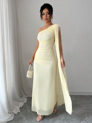 Mujer luciendo un vestido largo estilo diosa griega con un hombro descubierto y tela drapeada.
