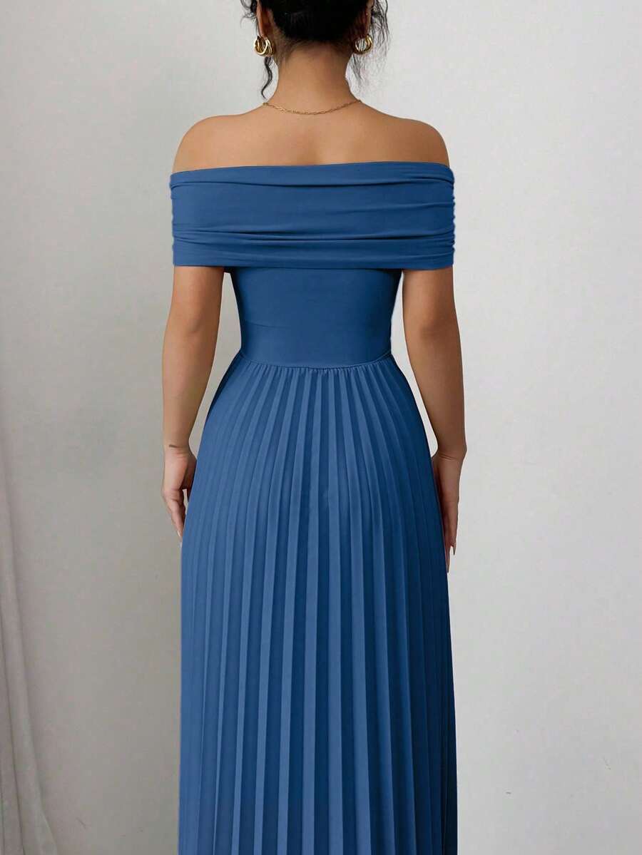 Mujer modelando un vestido largo elegante de color azul petróleo con falda plisada y escote de hombros descubiertos.