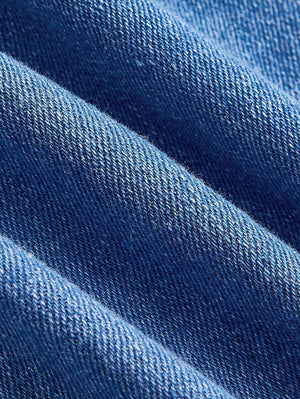 Detalle del torso del vestido denim mostrando costuras estilo corsé.