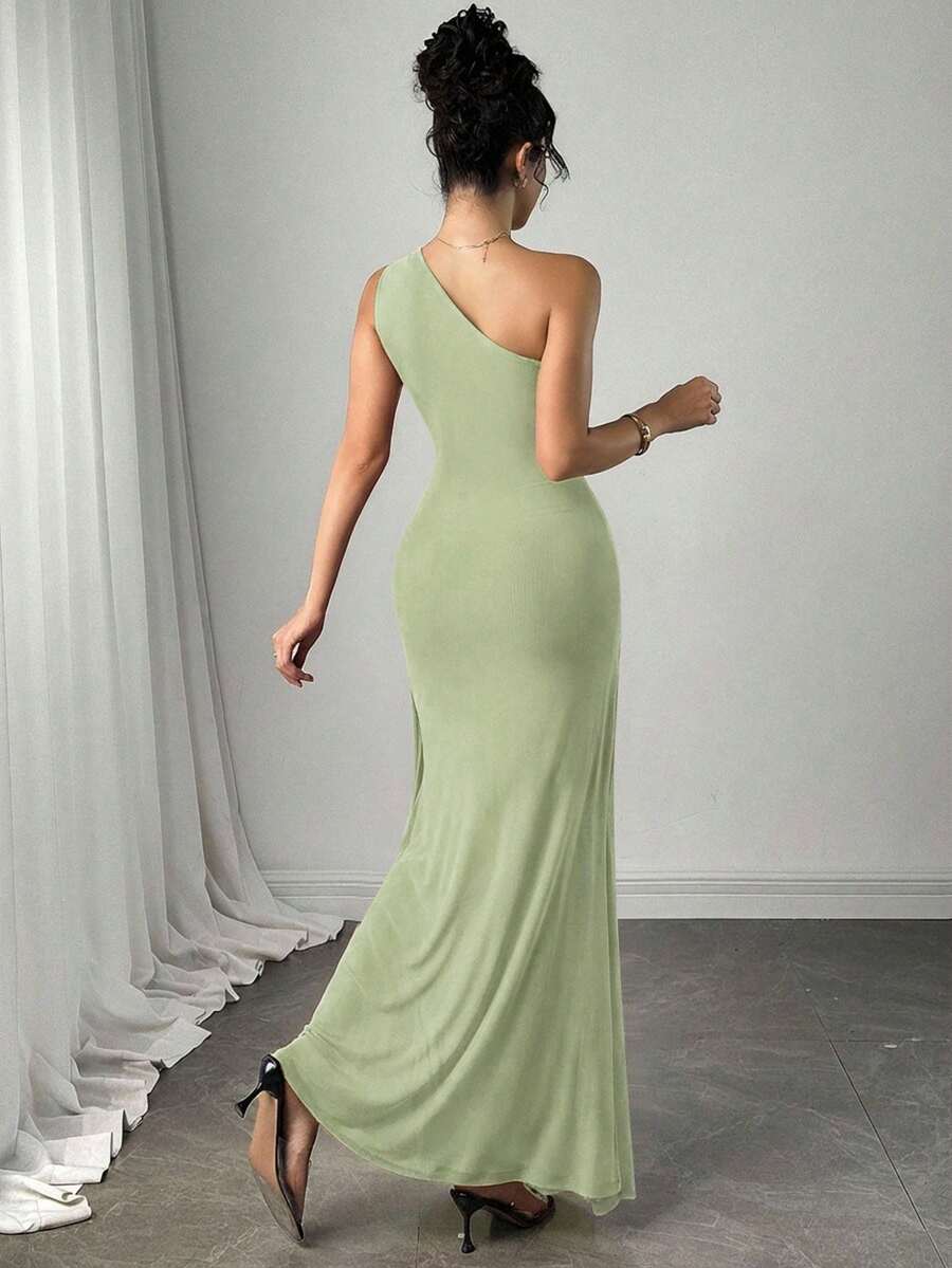 Vista completa de una mujer luciendo un vestido largo asimétrico color verde menta con drapeado en el cuerpo.