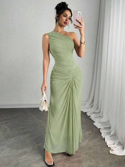 Vista completa de una mujer luciendo un vestido largo asimétrico color verde menta con drapeado en el cuerpo.