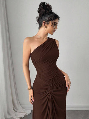 Detalle de la parte inferior del vestido largo marrón, mostrando la caída de la tela y los zapatos de la modelo.
