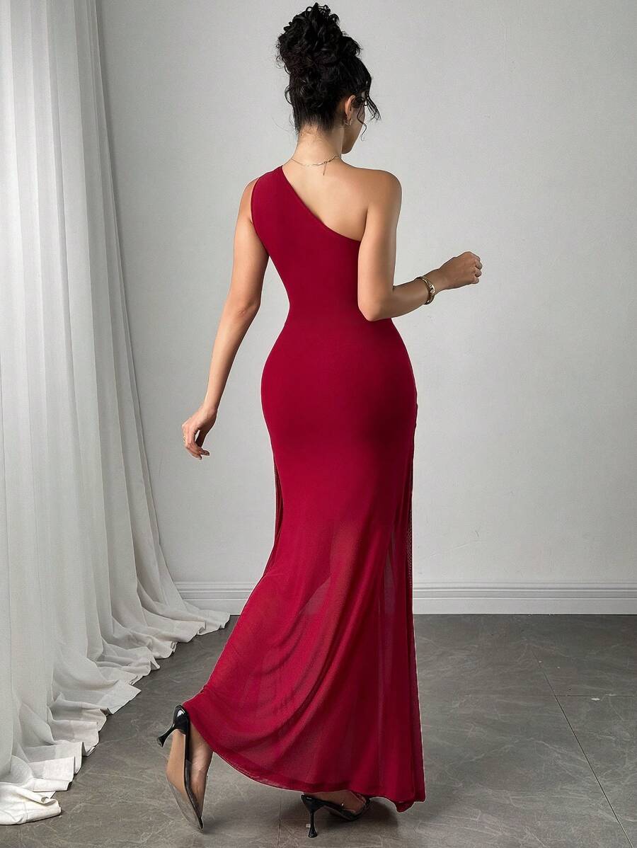 Modelo posando con vestido maxi vino de un hombro y detalle fruncido, con cartera blanca y sandalias transparentes.