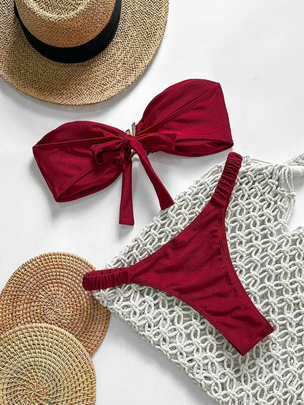 [Vista general del Bikini Rojo Bandeau Con Anilla sobre accesorios de playa.]