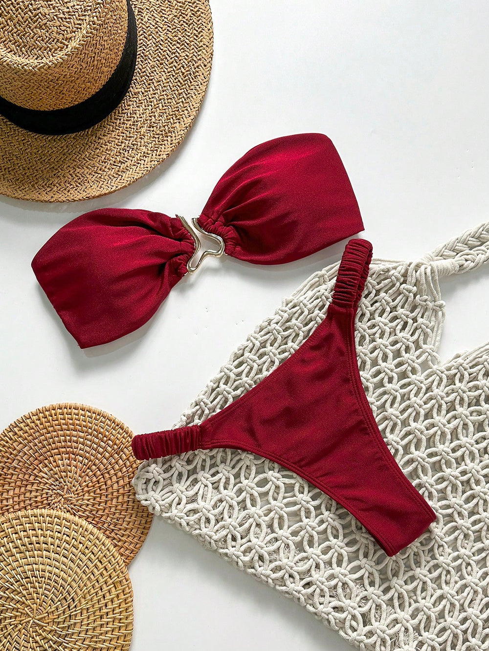 [Vista general del Bikini Rojo Bandeau Con Anilla sobre accesorios de playa.]