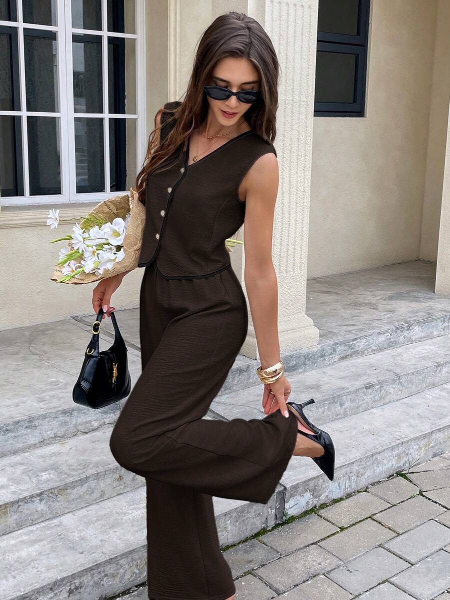 Mujer con conjunto elegante de chaleco y pantalón marrón de pierna ancha posando en escaleras.