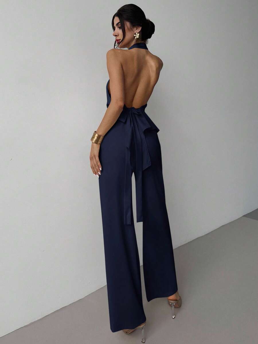 Mujer posando de lado con un conjunto elegante de dos piezas en color azul marino.