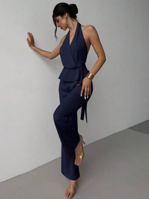 Mujer posando de lado con un conjunto elegante de dos piezas en color azul marino.