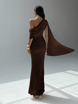 Vista de perfil de un vestido maxi asimétrico color café con detalle de capa fluida.