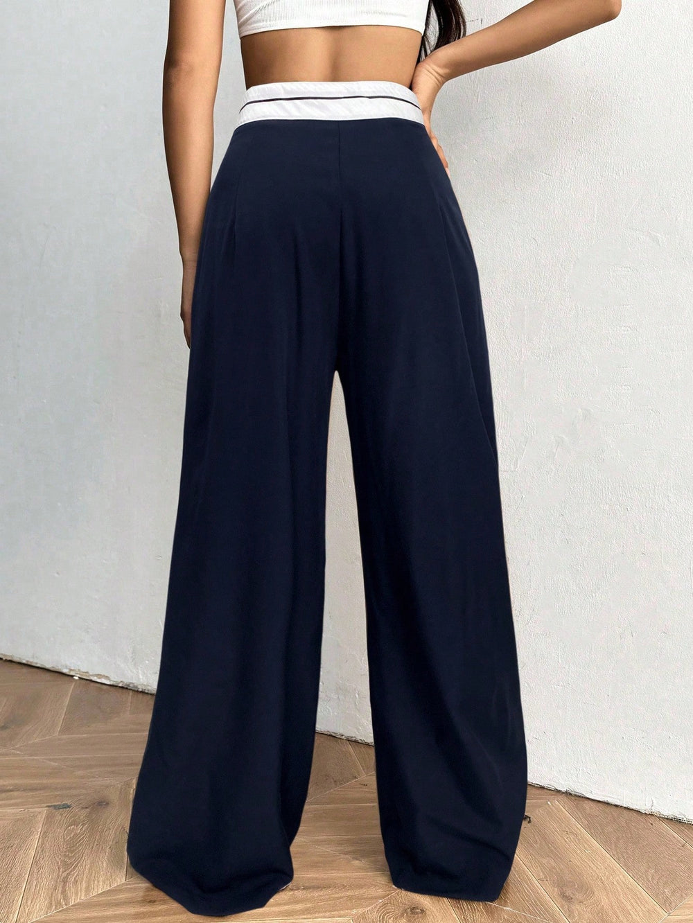 Pantalón azul marino de pierna ancha con detalle a rayas vista frontal.