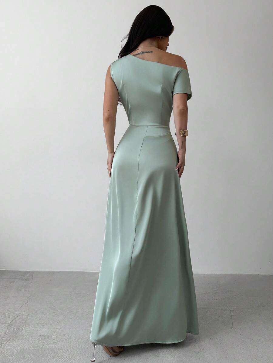 Mujer modelando un vestido largo de satín color verde menta con escote asimétrico y un solo hombro.