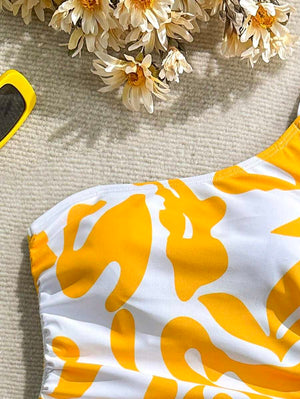 Detalle del estampado floral abstracto amarillo y blanco del bañador, con fruncido lateral ajustable.