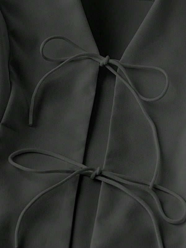 Detalle del escote y los nudos decorativos del conjunto negro casual