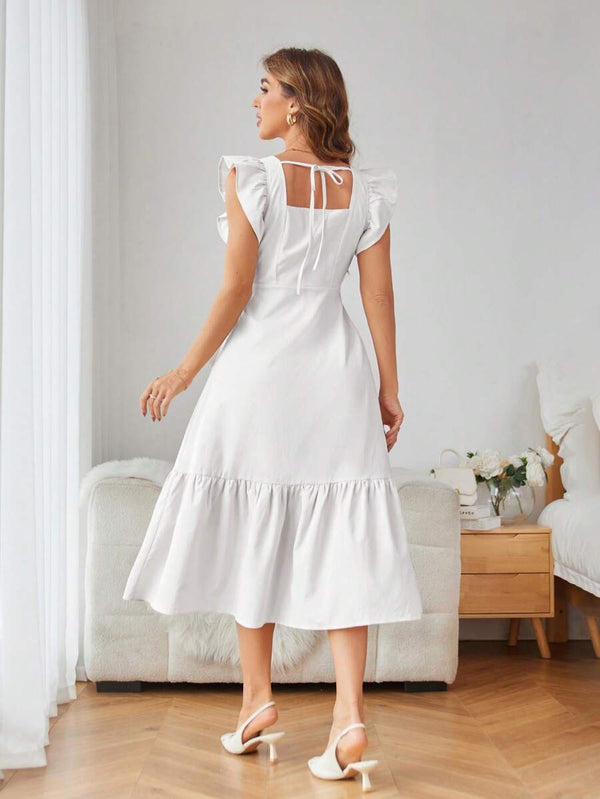 Vestido blanco elegante con bajo en volantes visto de espaldas.