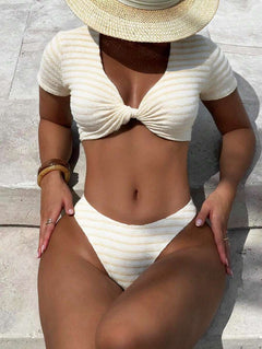 Vista frontal de mujer usando un conjunto de bikini color crema con textura de rayas y nudo frontal.