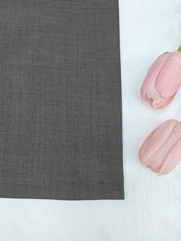 Primer plano de la parte inferior de un jumpsuit gris, destacando la caída fluida de la pierna ancha.