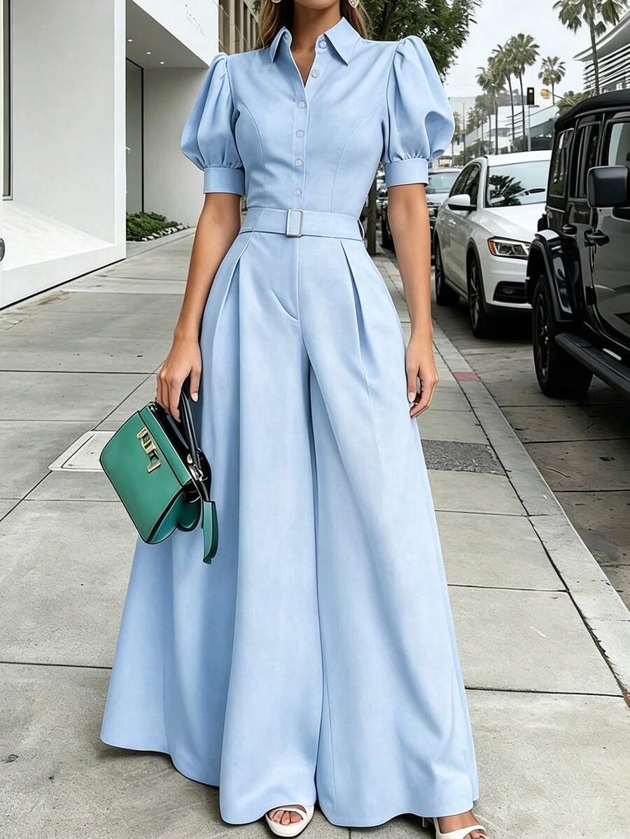Mujer vistiendo un jumpsuit elegante azul cielo de manga corta abullonada y pantalón palazzo en una acera de la ciudad.