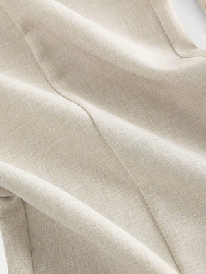 Silueta del jumpsuit beige con cintura entallada y pantalones palazzo.