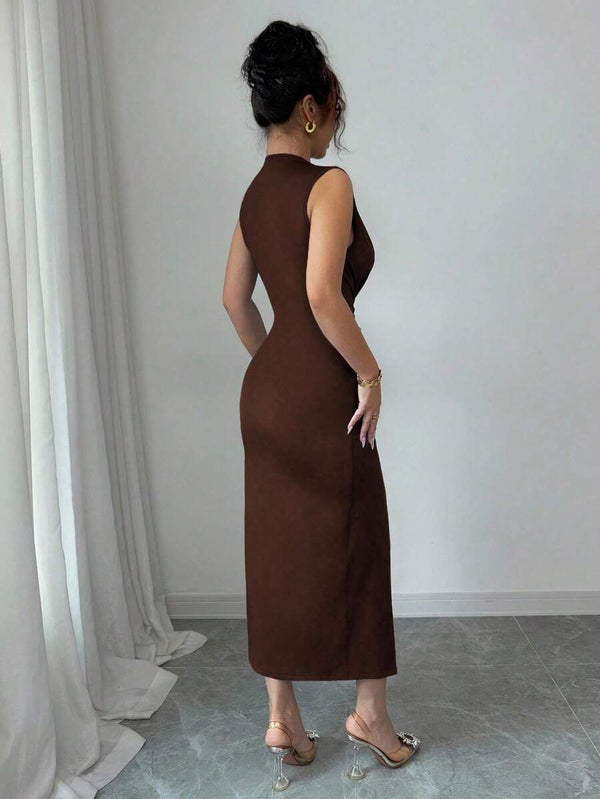 Detalle del escote en V profundo y el nudo fruncido en la cintura del vestido marrón.