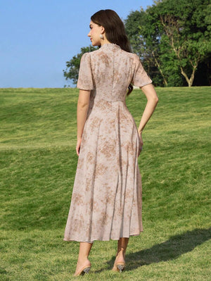 Primer plano del torso de una mujer con vestido beige de estampado floral y cuello con lazo.
