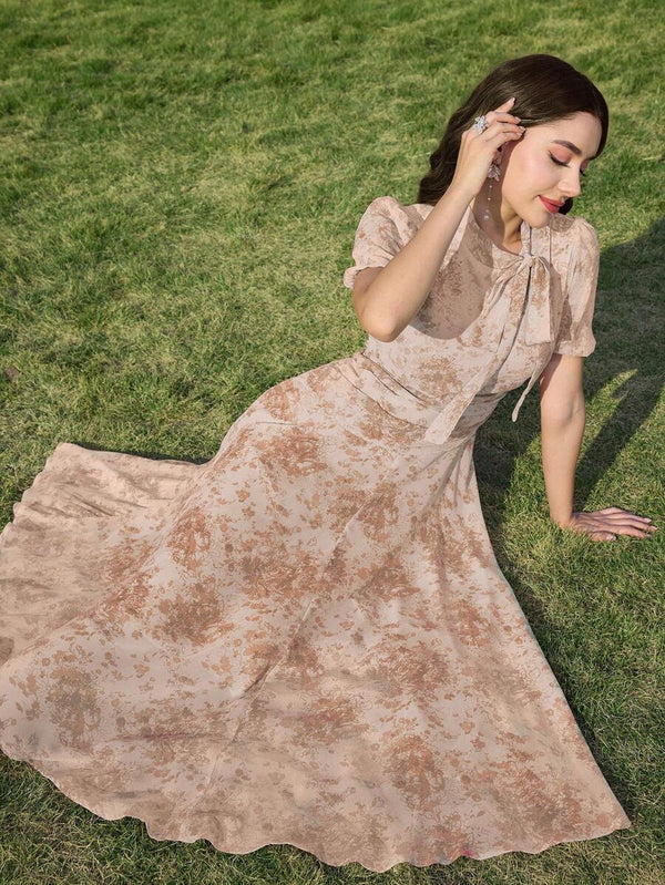 Detalle de la falda fluida de un vestido midi floral beige moviéndose al caminar.