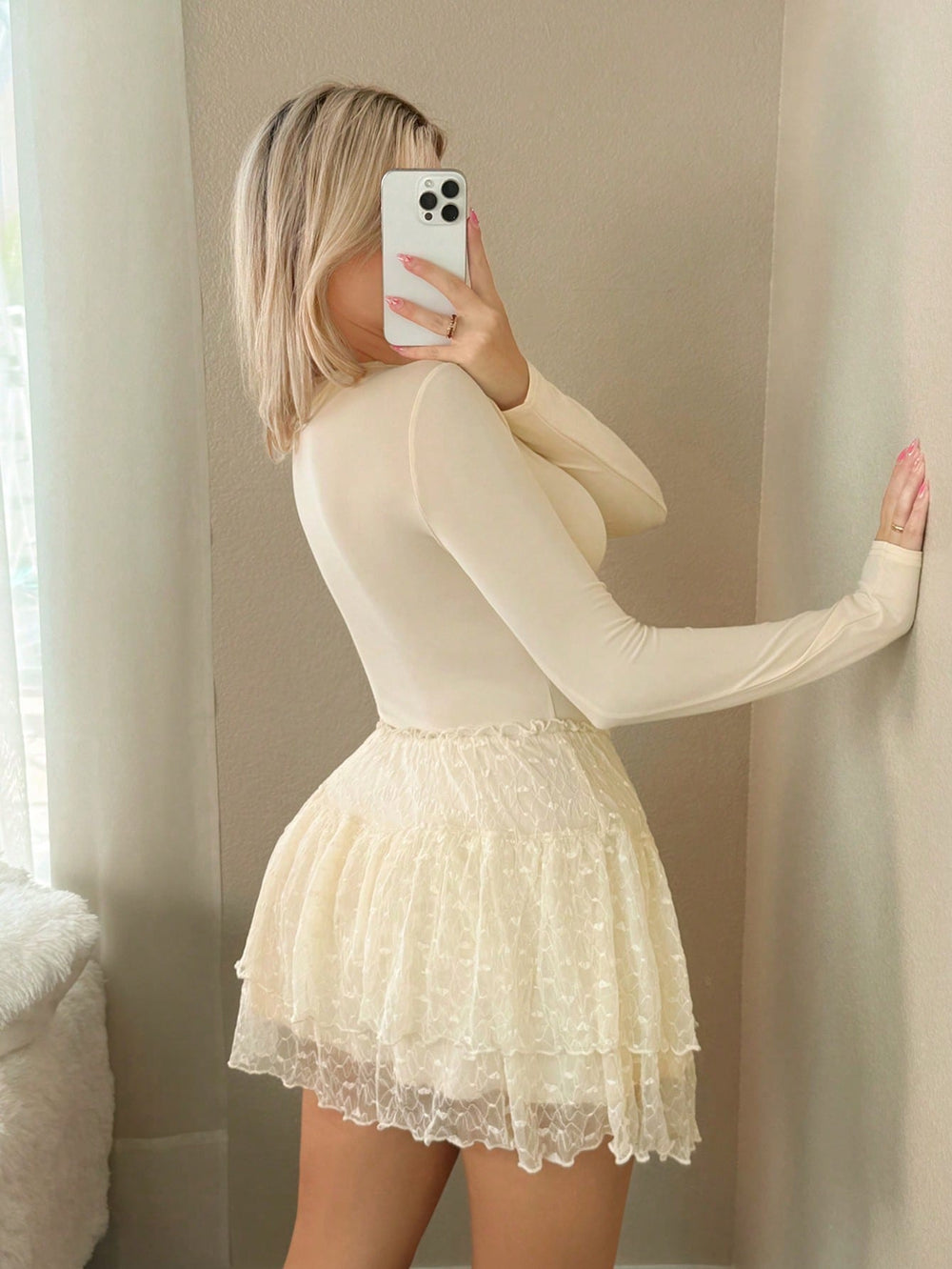 Imagen 1: Mujer modelando el Vestido Corto De Vuelos Albaricoque tomando una foto frente al espejo.