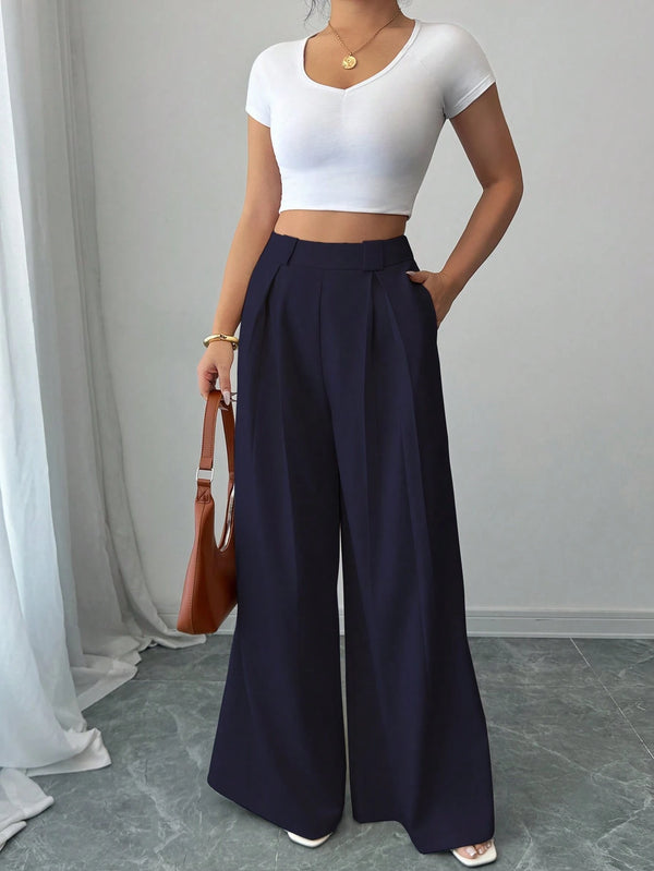 Modelo con pantalón azul marino elegante y bolso marrón