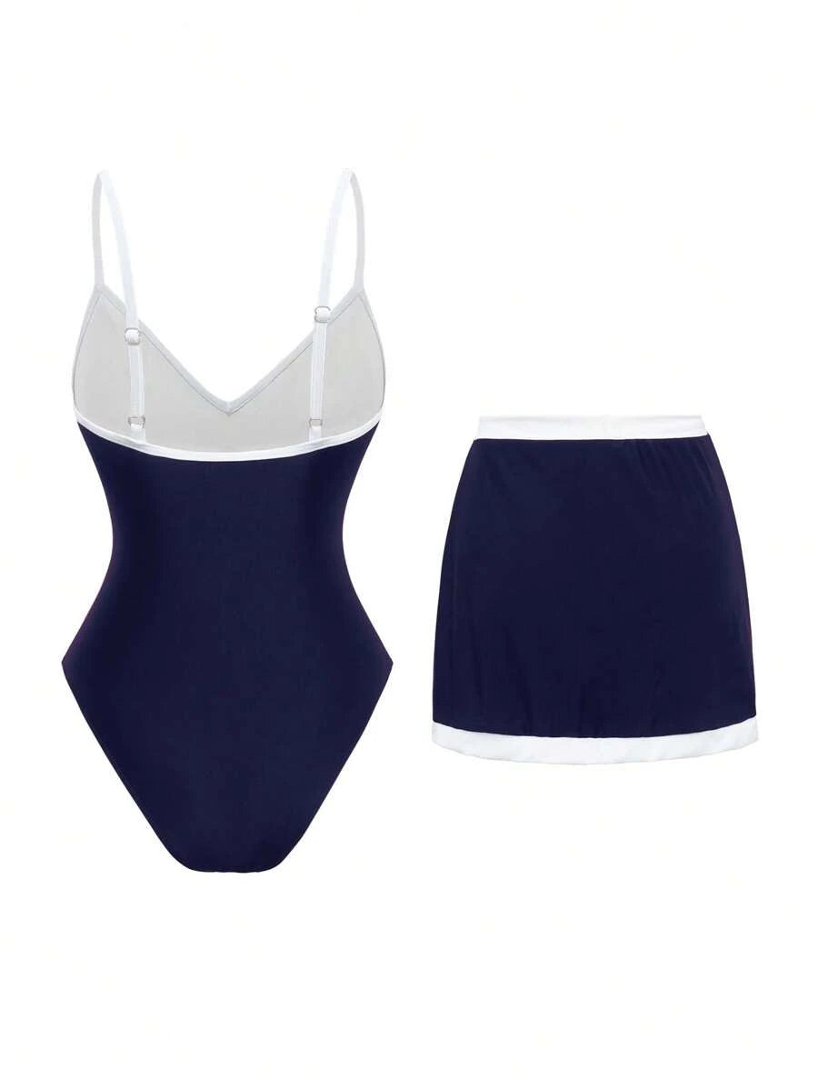 Look completo de conjunto de traje de baño azul marino con falda, sandalias negras, bolso de paja y lentes de sol.
