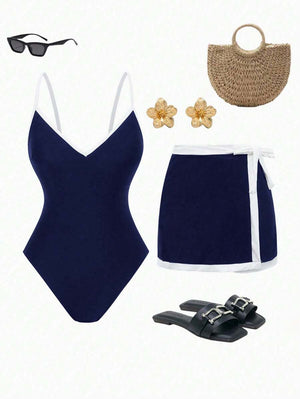 Look completo de conjunto de traje de baño azul marino con falda, sandalias negras, bolso de paja y lentes de sol.