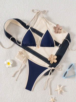 Detalle de la parte inferior de un bikini azul marino con lazos laterales y ribete a contraste.