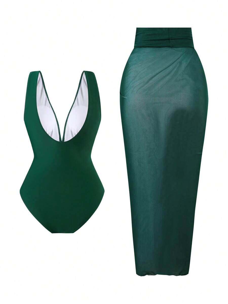 Conjunto de traje de baño de una pieza verde oscuro con escote en v y detalle dorado, junto a un pareo de malla a juego.