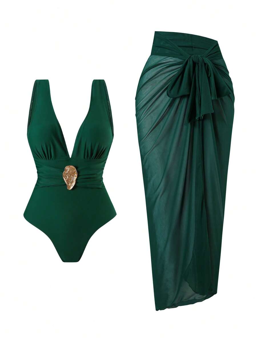 Conjunto de traje de baño de una pieza verde oscuro con escote en v y detalle dorado, junto a un pareo de malla a juego.