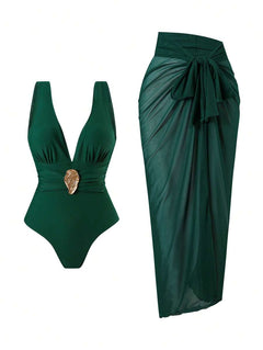 Conjunto de traje de baño de una pieza verde oscuro con escote en v y detalle dorado, junto a un pareo de malla a juego.