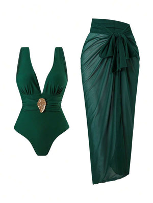 Conjunto de traje de baño de una pieza verde oscuro con escote en v y detalle dorado, junto a un pareo de malla a juego.