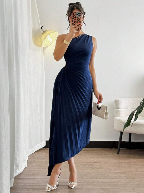 Detalle de la falda midi plisada y el bajo asimétrico de un vestido elegante color azul marino.