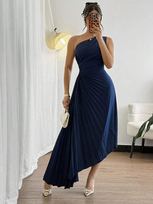 Una mujer luciendo un sofisticado vestido de fiesta azul marino con escote de un hombro.