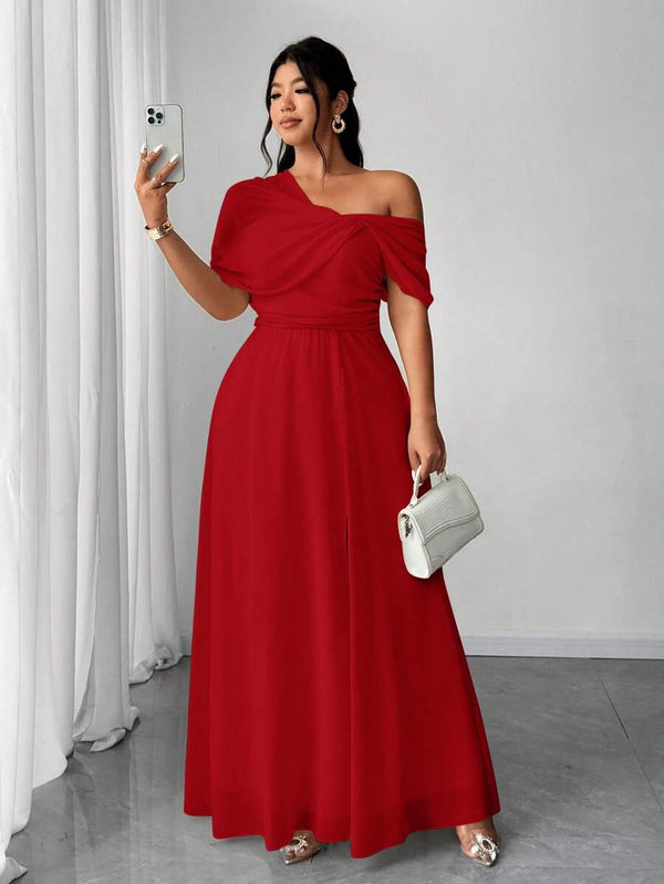 Detalle de la falda larga de un vestido rojo mostrando la abertura lateral y el tejido fluido.
