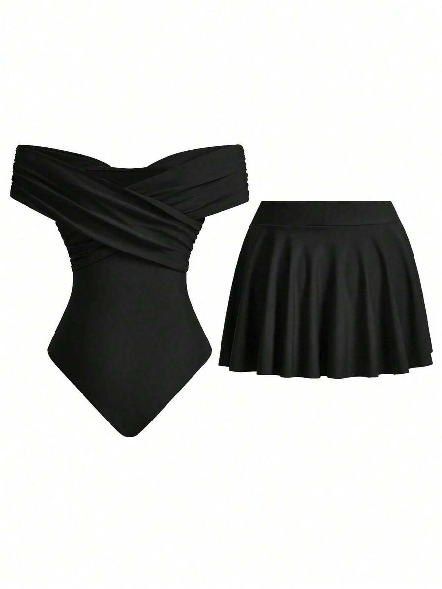 Conjunto de traje de baño negro de dos piezas con bañador de hombros descubiertos y falda corta acampanada, sobre fondo blanco.