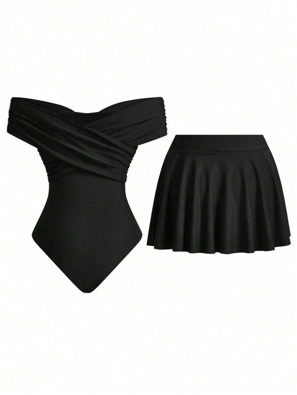 Detalle del escote cruzado y hombros descubiertos del traje de baño negro.