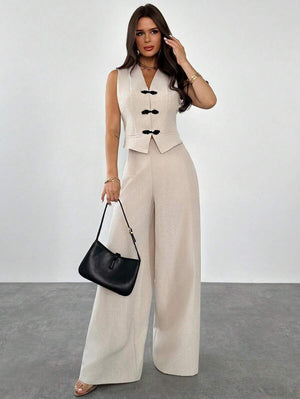 Detalle del chaleco beige con escote en V y broches de alamar negros.