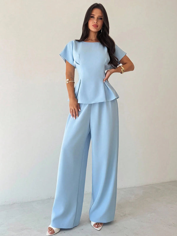 Blusa azul elegante con corte peplum y manga murciélago.