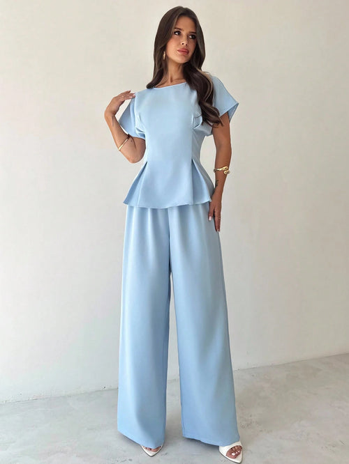 Conjunto azul elegante con blusa asimétrica y pantalón largo.