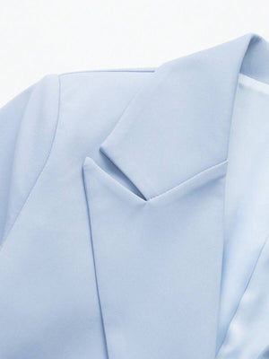Primer plano de los botones negros y bolsillos de un blazer celeste.